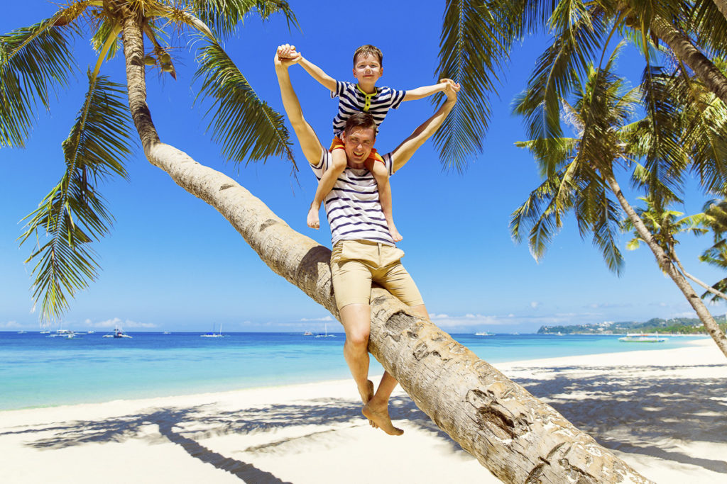 Karibikurlaub mit Kindern, Vater und Sohn am Strand